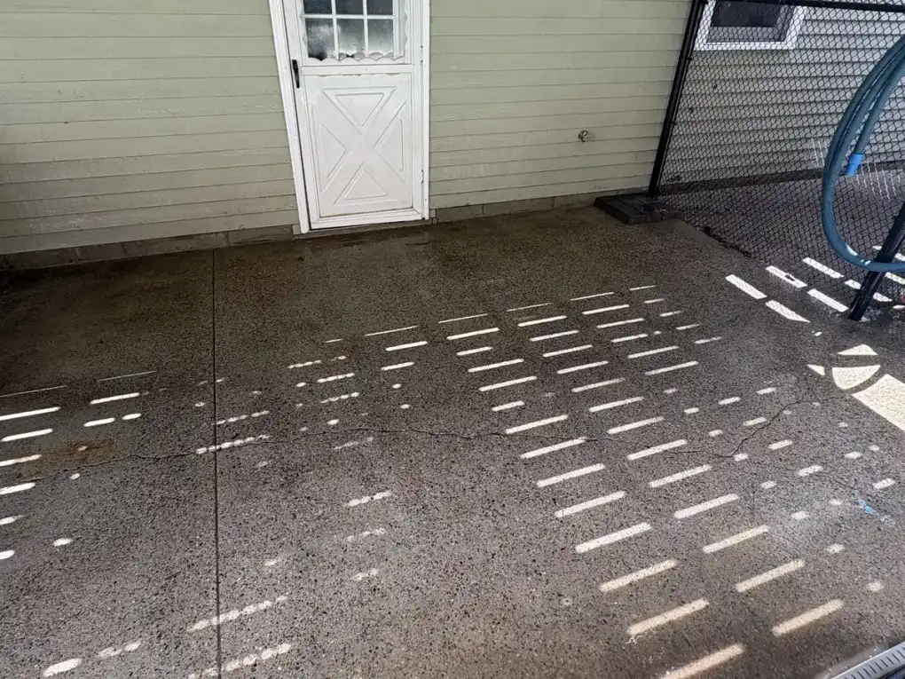 Dirty concrete patio with algae and stains before pressure washing in Upton MA