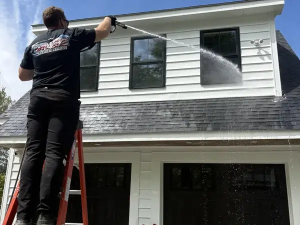 Drake Power Washing technician pressure washing house siding at Campbells Station job site