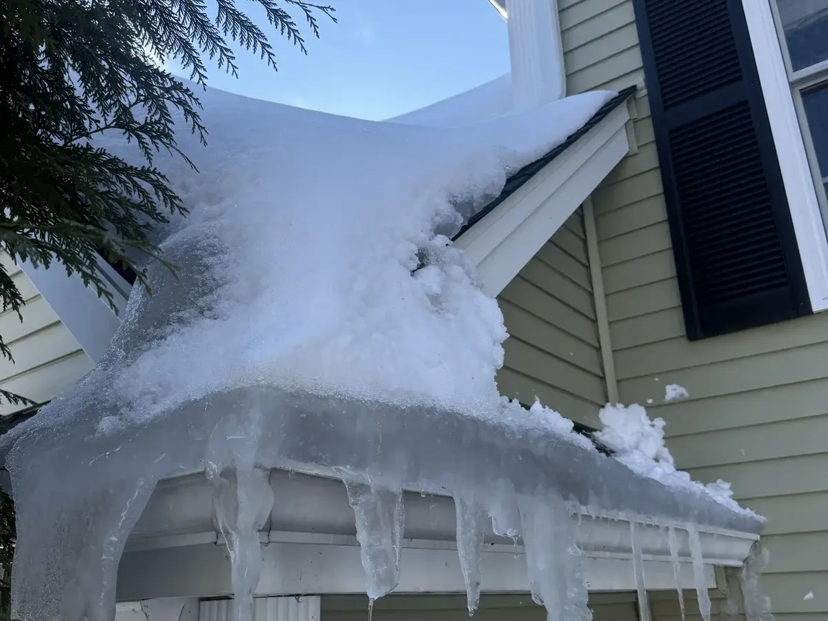 Roof with heavy ice dam buildup along eaves