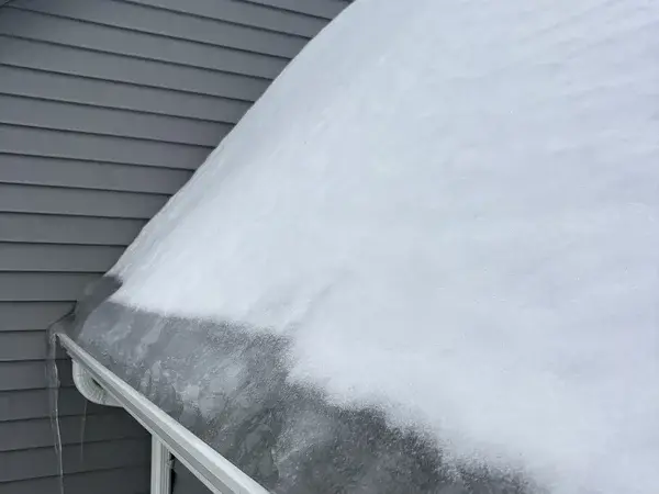 Roof completely covered in thick snow and ice before removal