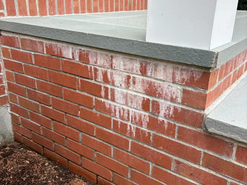 Commercial brick building entrance with efflorescence deposits