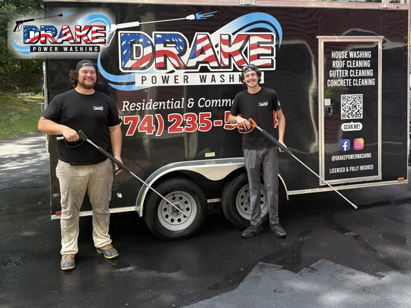 Drake Power Washing crew with pressure-washing equipment beside their branded trailer in Franklin MA