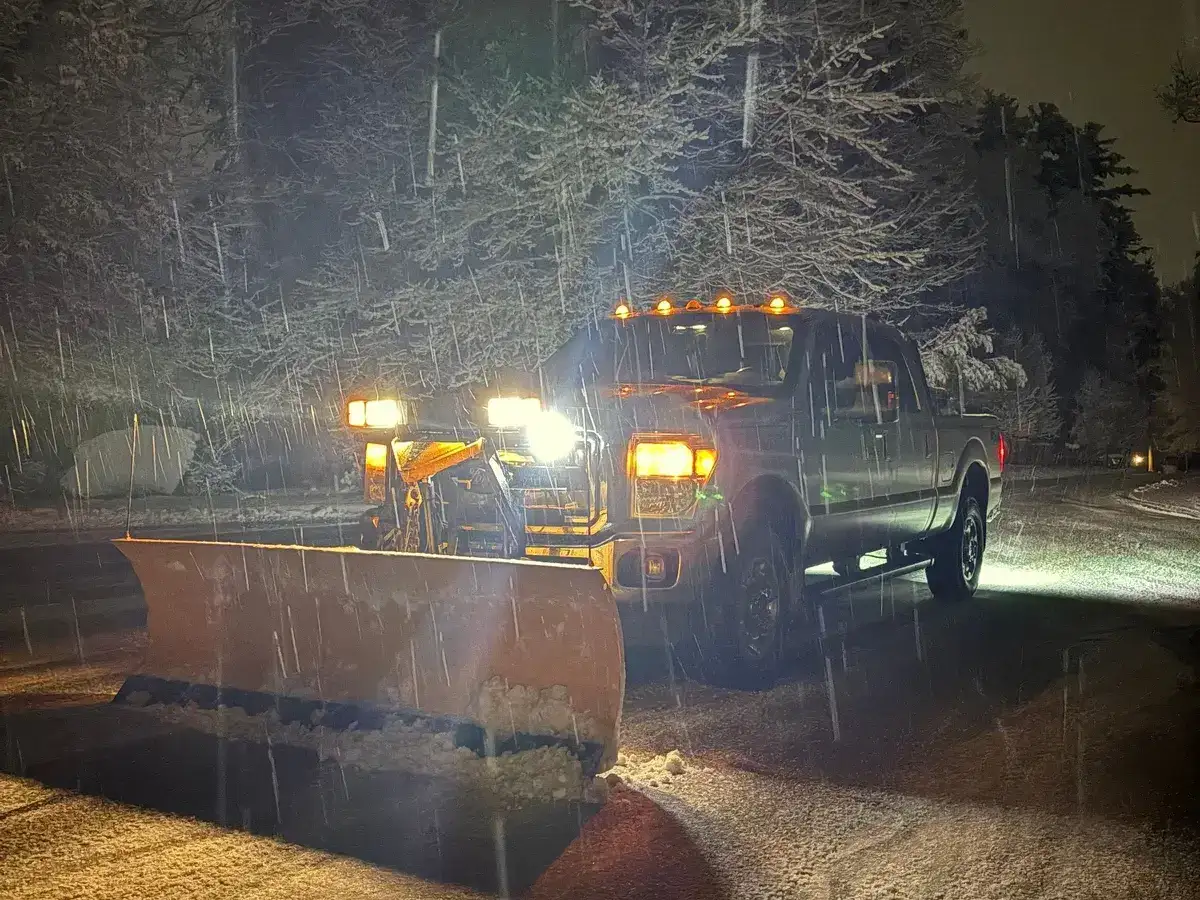 Drake Power Washing snow plow truck working during active winter storm at night