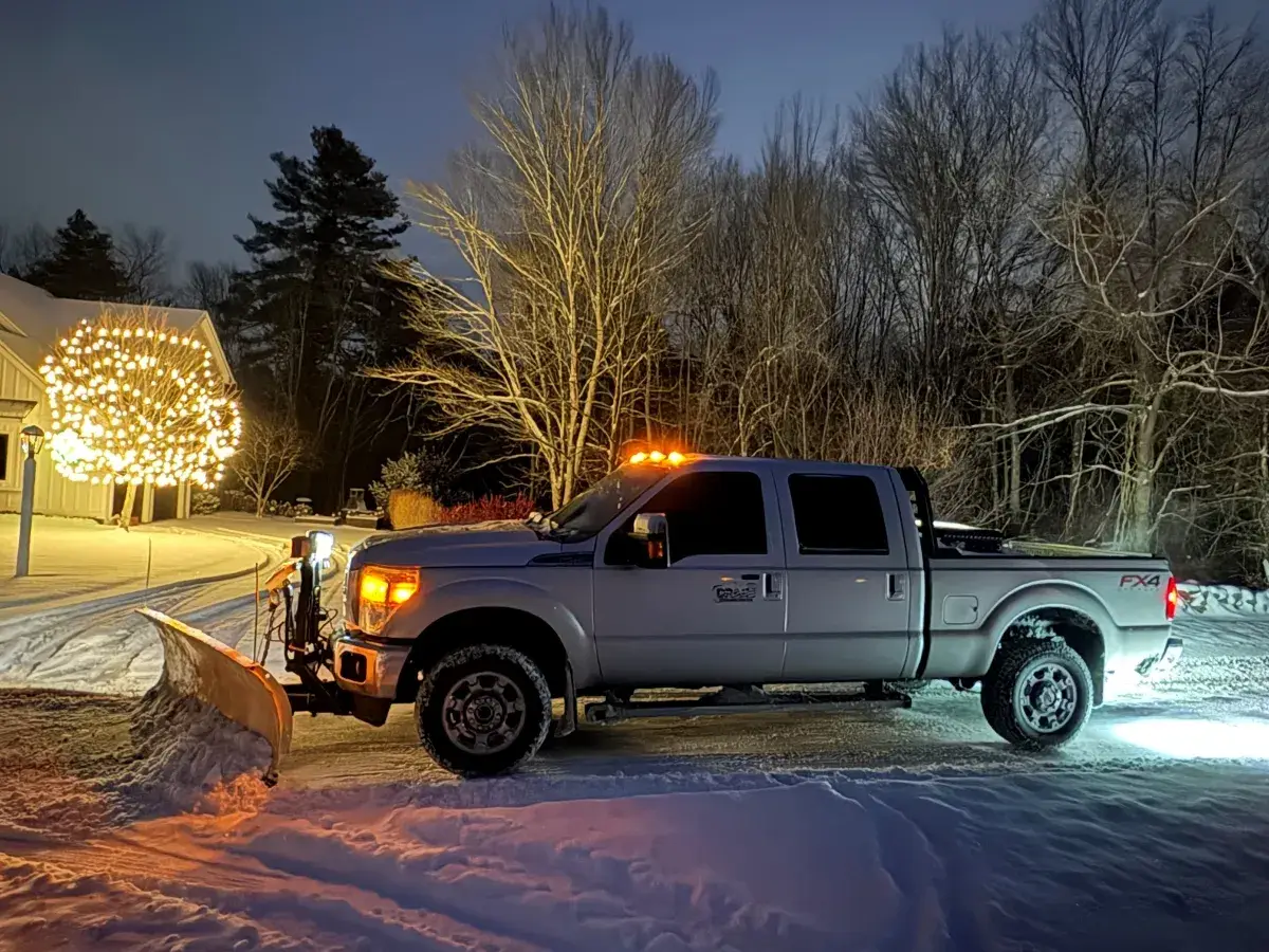 Drake Power Washing snow plowing service - truck with plow at night